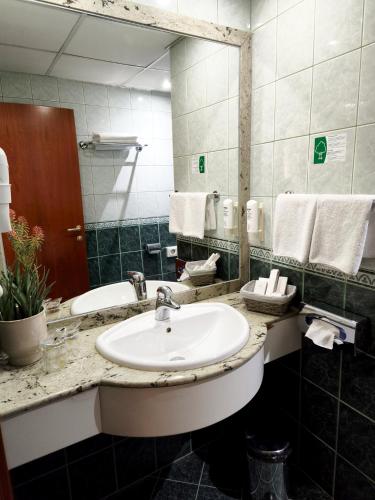 a bathroom with a sink and a mirror at Hotel Turist - City Center in Skopje