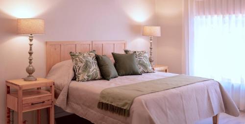 a bedroom with a bed and two lamps and a window at Scandi House in Louis Trichardt