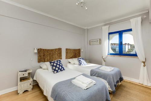 a bedroom with two beds and a window at Apartamento Mar Salgado Ericeira in Ericeira