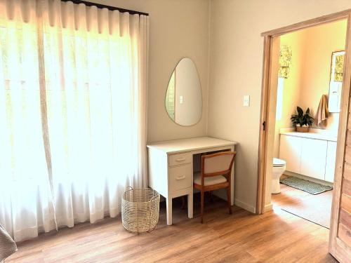 a bathroom with a dressing table and a mirror at Scandi House in Louis Trichardt