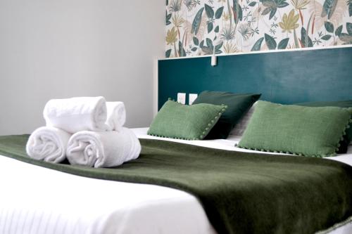 a bedroom with a bed with towels on it at Brit Hotel Le Surcouf in Saint Malo