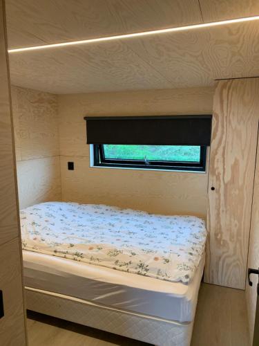 a small bedroom with a bed in a trailer at Cabin in the orchard in Sandane