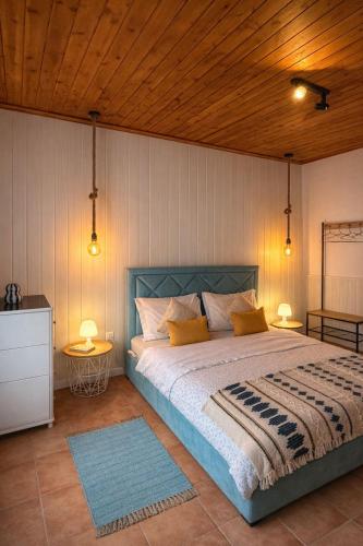 a bedroom with a bed with a wooden ceiling at Cantinho do Sol in Mosteiros