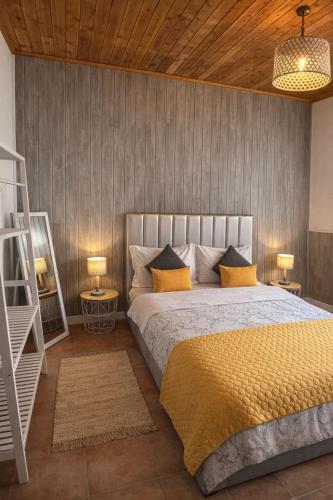 a bedroom with a large bed with yellow pillows at Cantinho do Sol in Mosteiros