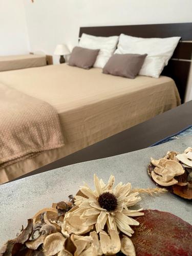 a bedroom with a bed with a flower on a table at A casa di Nonna Maria in Marsala