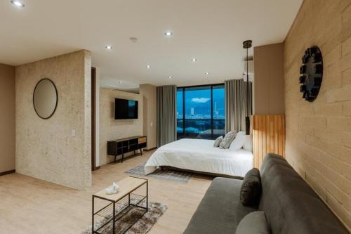 a large bedroom with a bed and a couch at Cozy Loft in Class 48 in Sabaneta