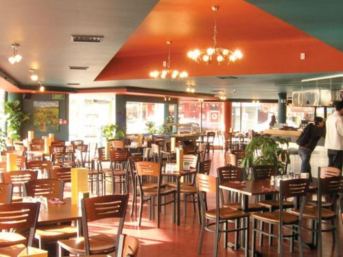 a restaurant with tables and chairs and people in the background at Rayland Motel in Auckland