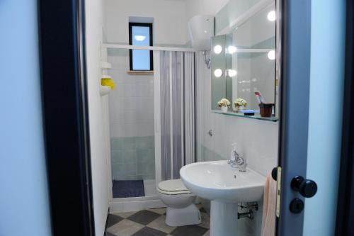 ポルト・エンペードクレにあるAl Caos Da Pirandello - Alloggio Vacanza Ufficioの白いバスルーム(洗面台、トイレ付)