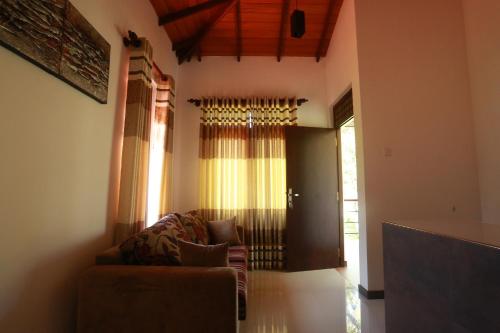 a living room with a couch and a window at River Breeze Villa Bentota in Bentota