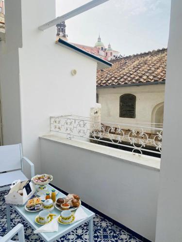 a table with plates of food on a balcony at Dolce Pausa in Atrani