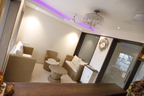 a room with chairs and a table and a chandelier at Hotel Center Point in Bhubaneshwar