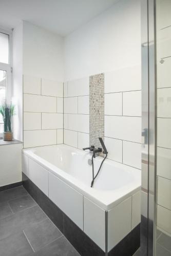 a bath tub with a faucet in a bathroom at Ruhiges City-Wohnapartment - 5 min zum Markplatz in Annaberg-Buchholz