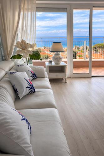 a living room with a couch with a view of the ocean at Due Passi dal Cielo Apartment Piscina Condominiale fino al 30 Agosto in Anzio