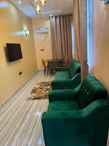 a waiting room with green couches and a table at Unique CityLife Hotel in Etoi