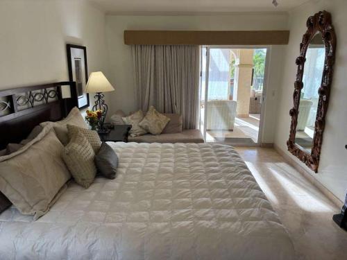 a bedroom with a large bed and a large mirror at Beautifully Maintained 2-Bed Condo in Las Mañanitas in San José del Cabo