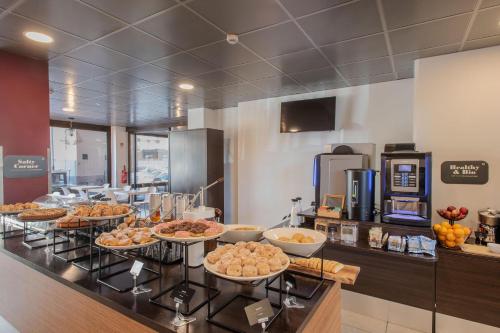 a buffet line with many plates of food on it at B&B Hotel Firenze Nuovo Palazzo Di Giustizia in Florence