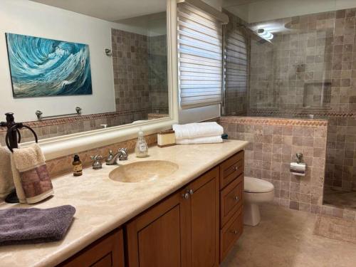 a bathroom with a sink and a toilet and a mirror at Beautifully Maintained 2-Bed Condo in Las Mañanitas in San José del Cabo