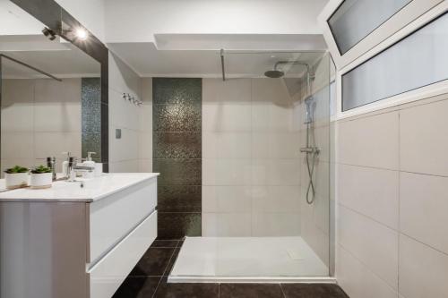 a white bathroom with a shower and a sink at Funchal Bay View Villa by Homie in Funchal