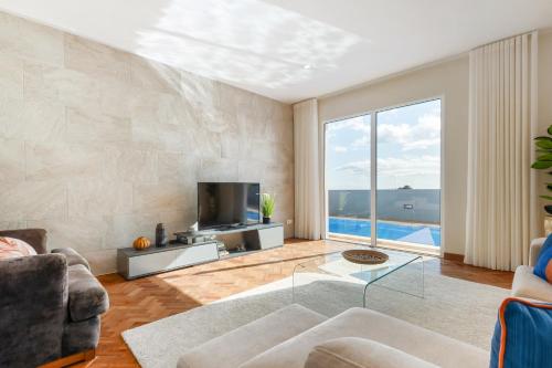 a living room with a couch and a tv at Funchal Bay View Villa by Homie in Funchal