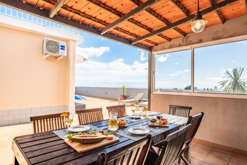 a dining room with a table with a view of the ocean at Funchal Bay View Villa by Homie in Funchal