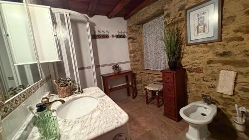a bathroom with a sink and a toilet at Rego de Cora By Oktheway in Valcarría