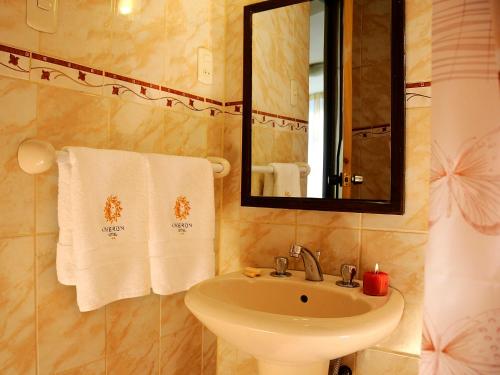 a bathroom with a sink and a mirror and towels at Hostal Ameron in Juliaca