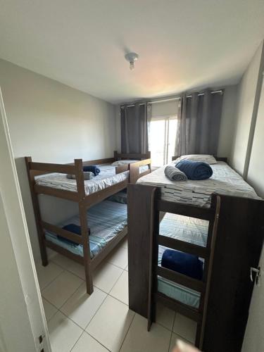 a small room with two bunk beds in it at Atlântico condomínio in Serra