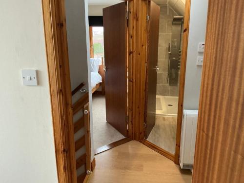 a hallway with a glass door leading to a bathroom at Apartment 2, Craigmore, Upper Baila, Lerwick in Lerwick