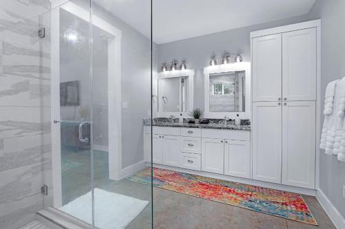 a bathroom with a glass shower and two sinks at Gatlin Getaway in Dripping Springs