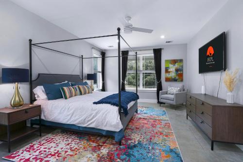 a bedroom with a canopy bed and a dresser and a chair at Gatlin Getaway in Dripping Springs