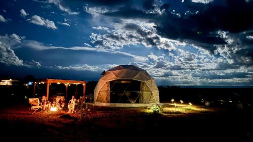 a tent in a field at night with lights at White Camel in Kanab