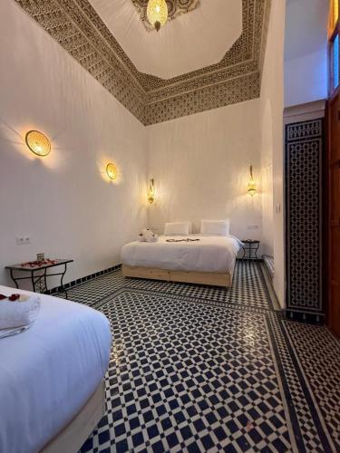 a bedroom with two beds and a coffered ceiling at Riad Mira in Fez