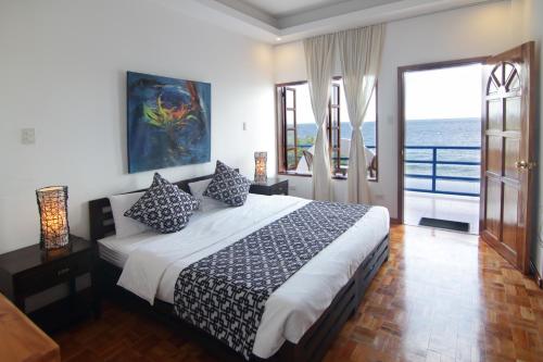 a bedroom with a bed with a view of the ocean at Villa in Blue in Dauin