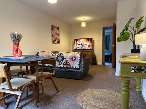 a living room with a couch and a table at The Garden Haven in Cheddar