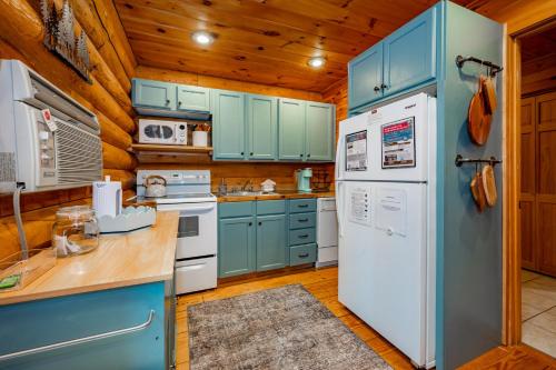 a kitchen with blue cabinets and a white refrigerator at Johnsons Creek Cabin by Railey Vacations in Oakland