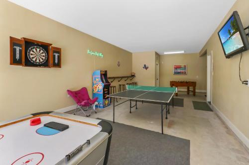 a room with a ping pong table and a tv at Green Roof Cottage in Canyon Lake