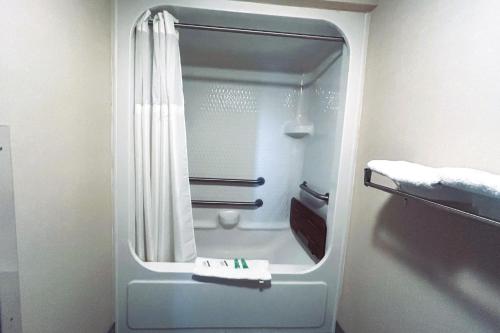 a bathroom with a shower with a mirror at Osage Village Inn Near Lake Ozarks US 54 in Osage Beach