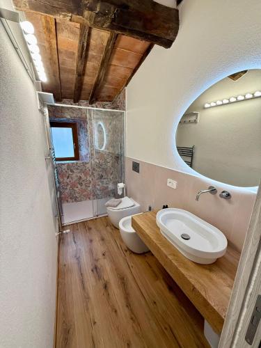a bathroom with a sink and a toilet and a mirror at CASA LALLINO - Tuscan ToBe srl in Santa Fiora
