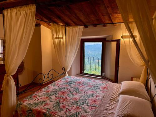 a bedroom with a bed with a large window at CASA LALLINO - Tuscan ToBe srl in Santa Fiora