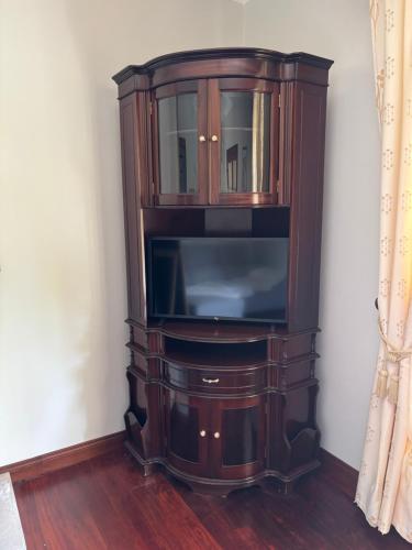 a wooden entertainment center with a flat screen tv at Quinta das Palmeiras in Povoação