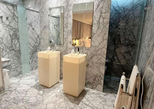 a bathroom with two sinks and a mirror at Nord Luxxor Citymix in Campina Grande