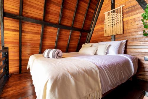 a bed in a room with wooden walls at Brisa Lofts Uluwatu in Uluwatu
