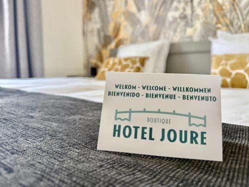 a sign on a bed with a hotel room at Boutique Hotel Joure - centrum & haven in Joure