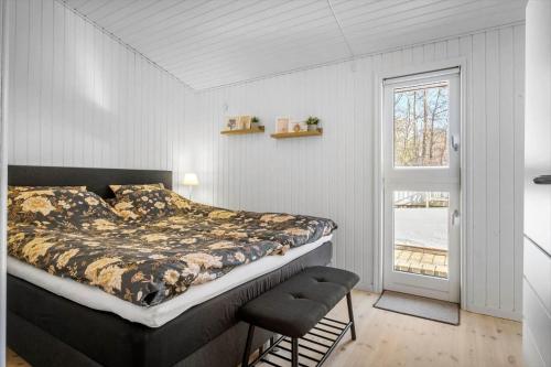 a bedroom with a bed and a chair and a window at BL1163-Blokhus-Raappenmark-2 in Blokhus