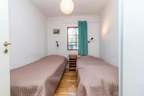two beds in a room with a window at VGO922-Grabo-Strandkullen-22 in Gråbo