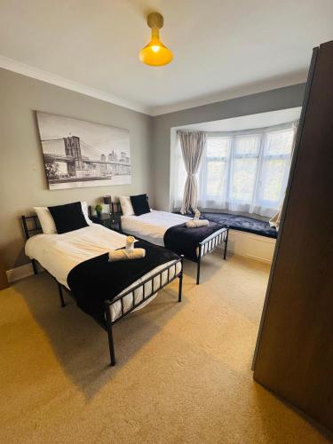 a bedroom with two beds and a window at Mayors House Ideal for Groups & Business in Peterborough