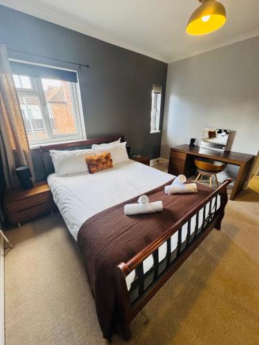 a bedroom with a large bed with two towels on it at Mayors House Ideal for Groups & Business in Peterborough