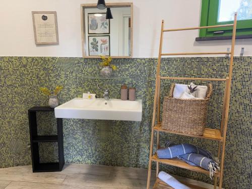 a bathroom with a sink and a shelf with towels at Is Cheas wine farm boutique hotel in San Vero Milis