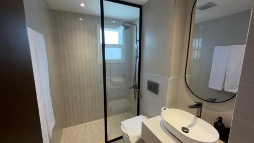 a bathroom with a sink and a shower with a mirror at Hatta Residence in Hatta