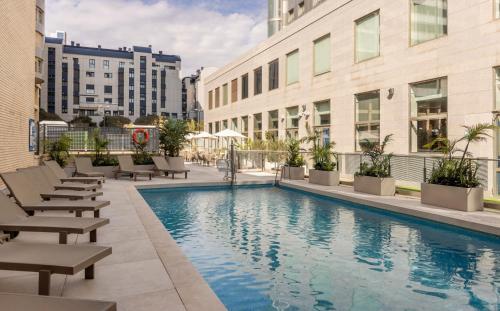 a swimming pool in the middle of a city with buildings at Ilunion Valencia 4 in Valencia